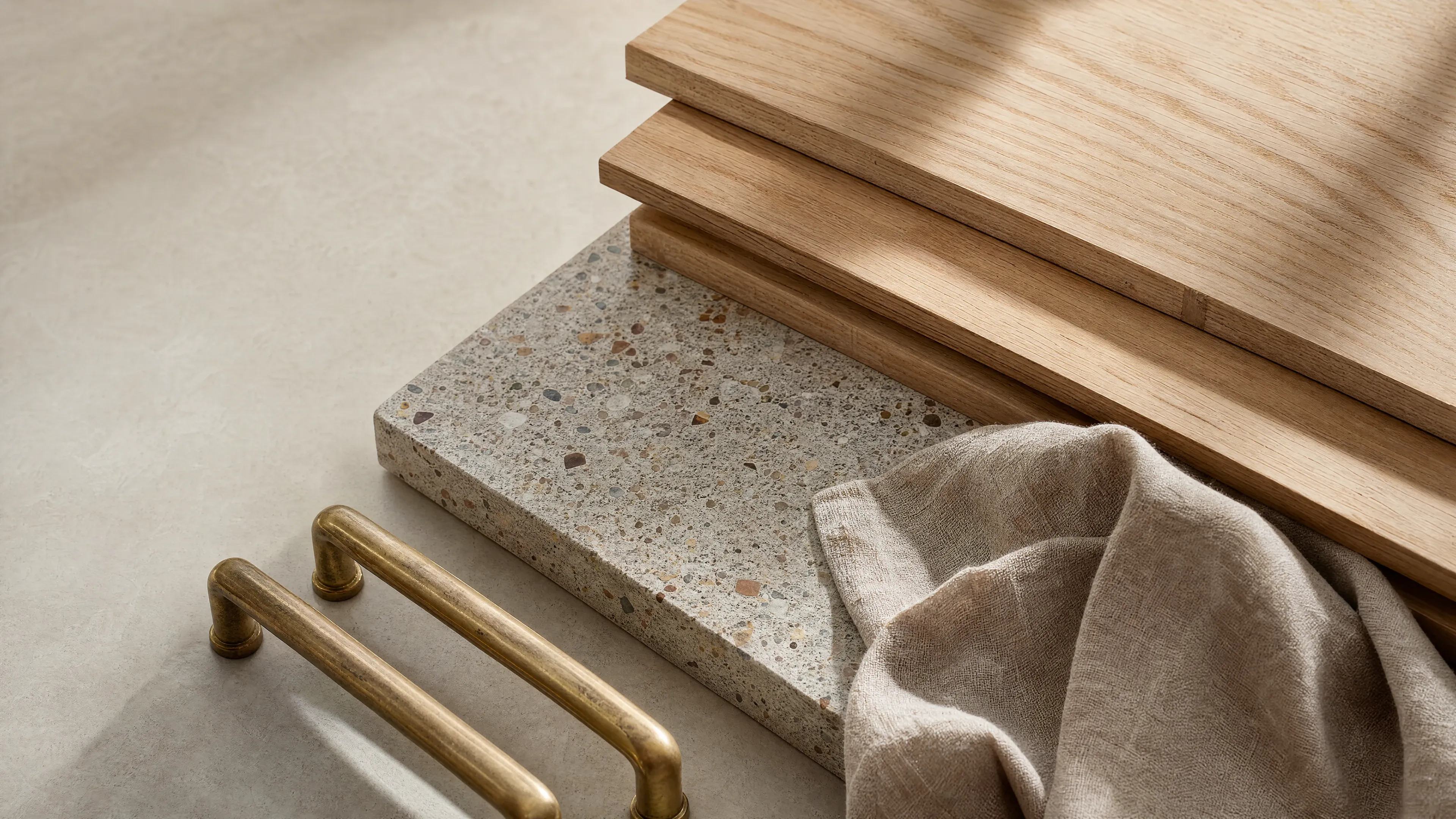 Wide still life of wood, stone, and brass material samples.